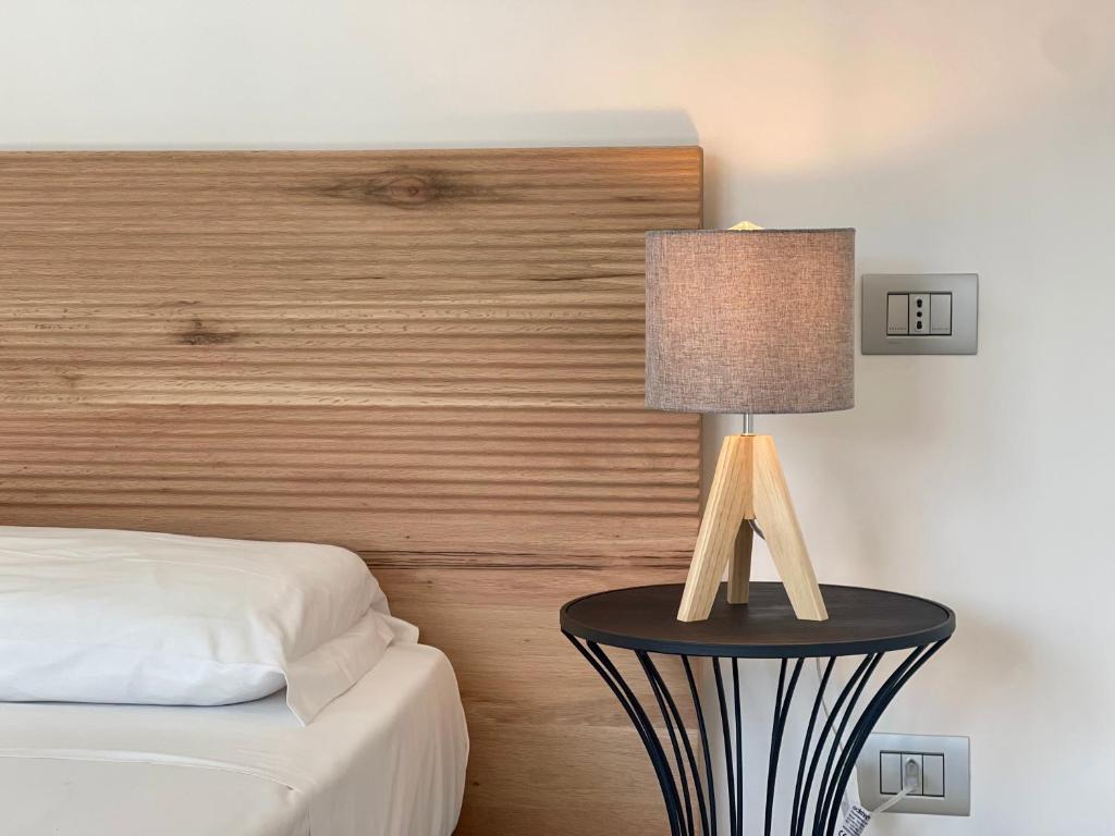 a bedroom with a bed and a table with a lamp at Daedalium in Marina di Palma