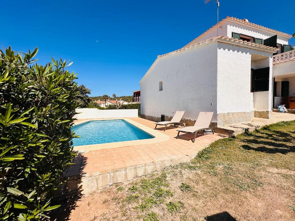 uma casa com piscina ao lado de uma casa em Minorque maison 4 chambres - licence touristique em Son Bou