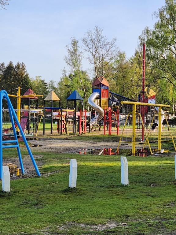 een park met een speeltuin met glijbanen en schommels bij Bungalow WILLERBY in Maasmechelen