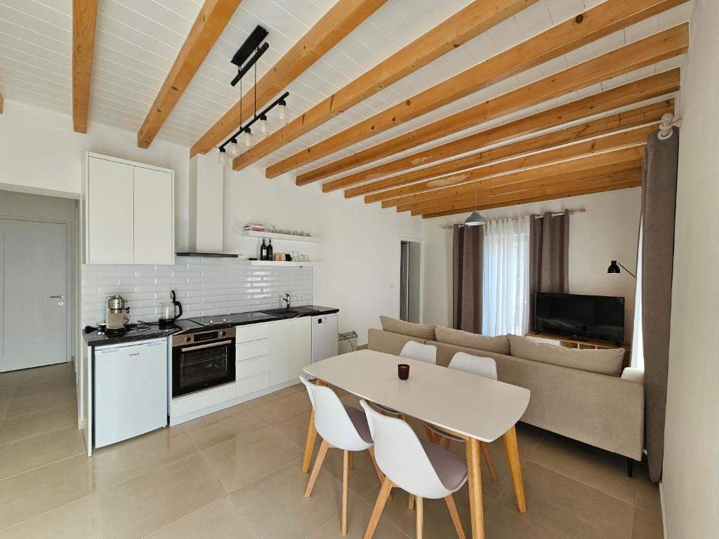een keuken en een woonkamer met een tafel en stoelen bij Vacation Domgjon in Rrëshen