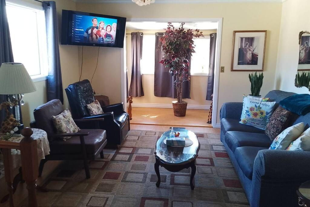 - un salon avec un canapé, des chaises et une télévision dans l'établissement Home Away from Home - Guest Suite 1, à Red Deer