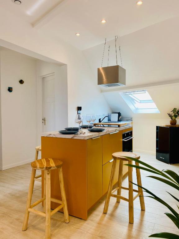 uma cozinha com uma ilha de madeira com dois bancos em Lou & Moi Appartement à 50m de la plage em Cayeux-sur-Mer