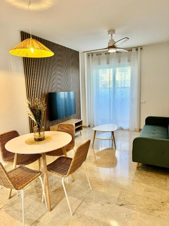 a living room with a table and a tv at Apartamento Vacacional Sol y Mar in Manilva