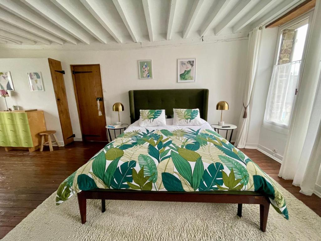 1 dormitorio con 1 cama con edredón verde y blanco en La Paix, Chambre d'Hôte en Suisse Normande en Condé-sur-Noireau