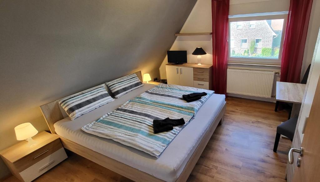 ein Schlafzimmer mit einem Bett mit zwei schwarzen Schuhen darauf in der Unterkunft Privates Doppelzimmer bei der Weser-Ems Halle in Oldenburg