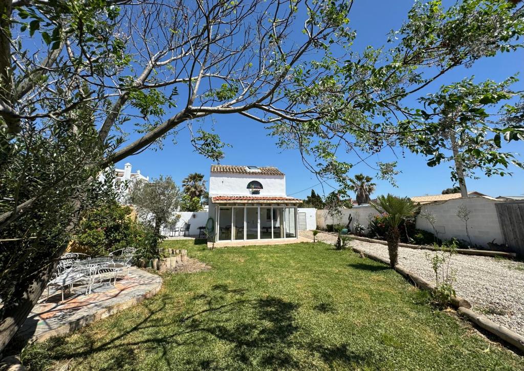 a house with a grass yard with a building at Cortijito dúplex Mangueta in El Palmar