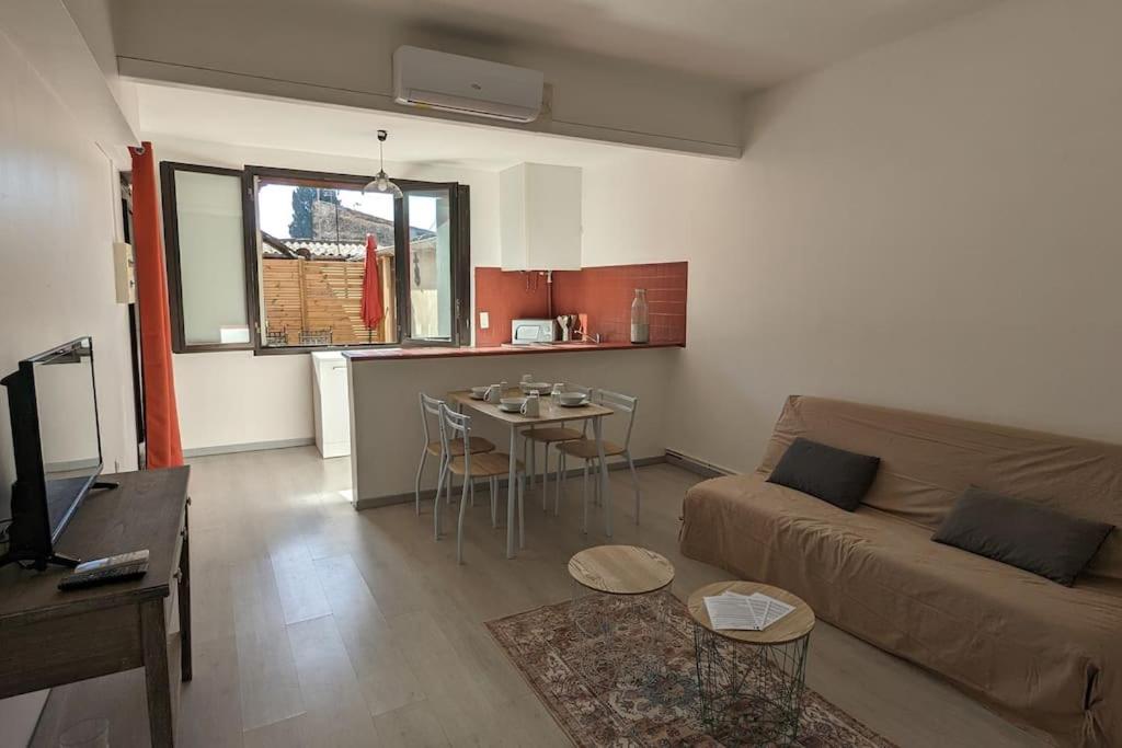 a living room with a couch and a table at Appartement intra-muros in Aigues-Mortes