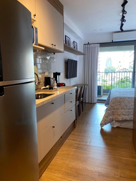 a kitchen with a sink and a refrigerator in a room at For You Moema 302 Studio da Andrea in São Paulo