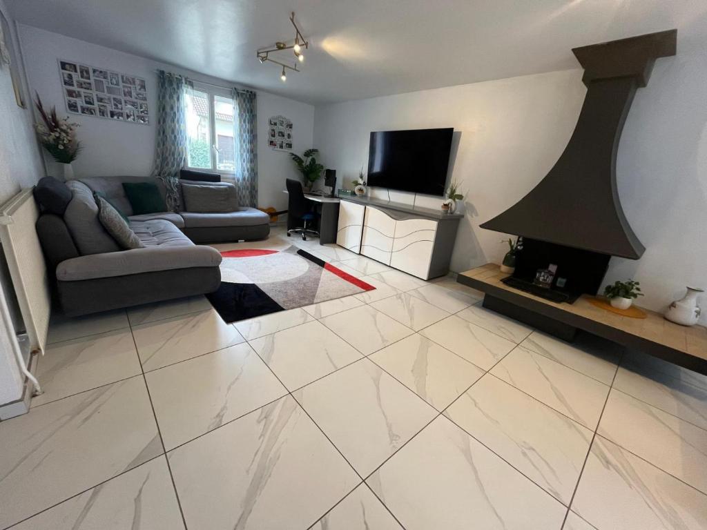 un salon avec un canapé et une cheminée dans l'établissement Maison quartier parc de Tremblay, à Champigny-sur-Marne