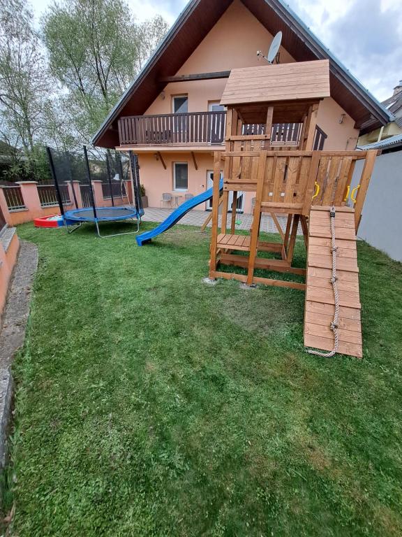 un gran patio con un parque infantil y una casa en Apartmany Star, en Liptovský Mikuláš