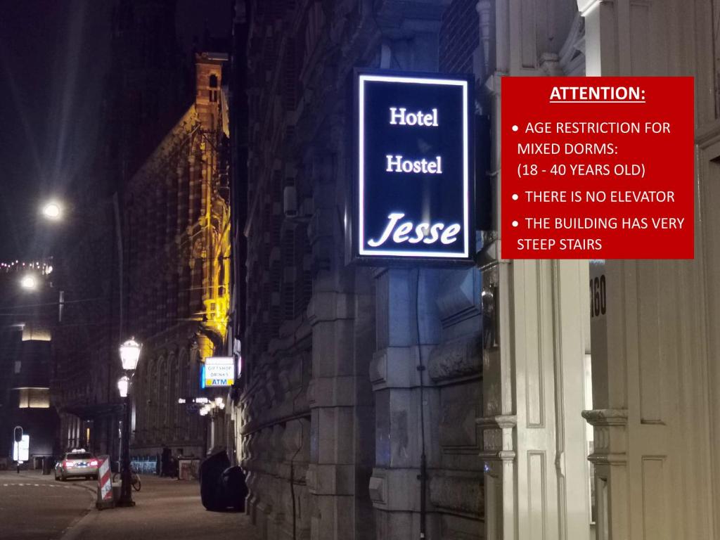a sign on the side of a building at night at Hotel Jesse in Amsterdam