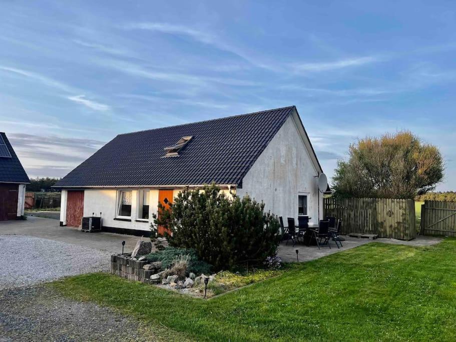 een klein wit huis met een zwart dak bij The Annex @ Bloksgaard in Hirtshals