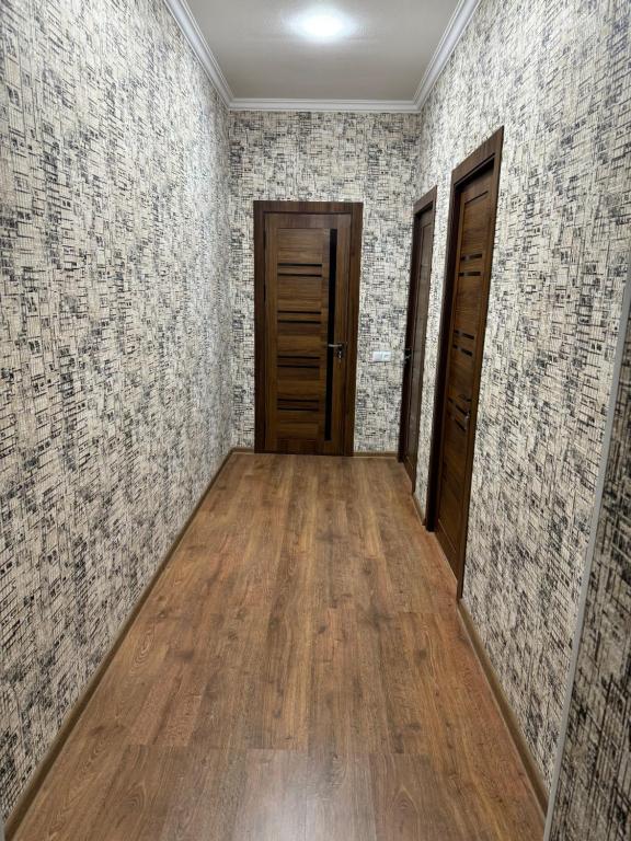 een lege kamer met houten vloeren en bakstenen muren bij Imran in Bukhara