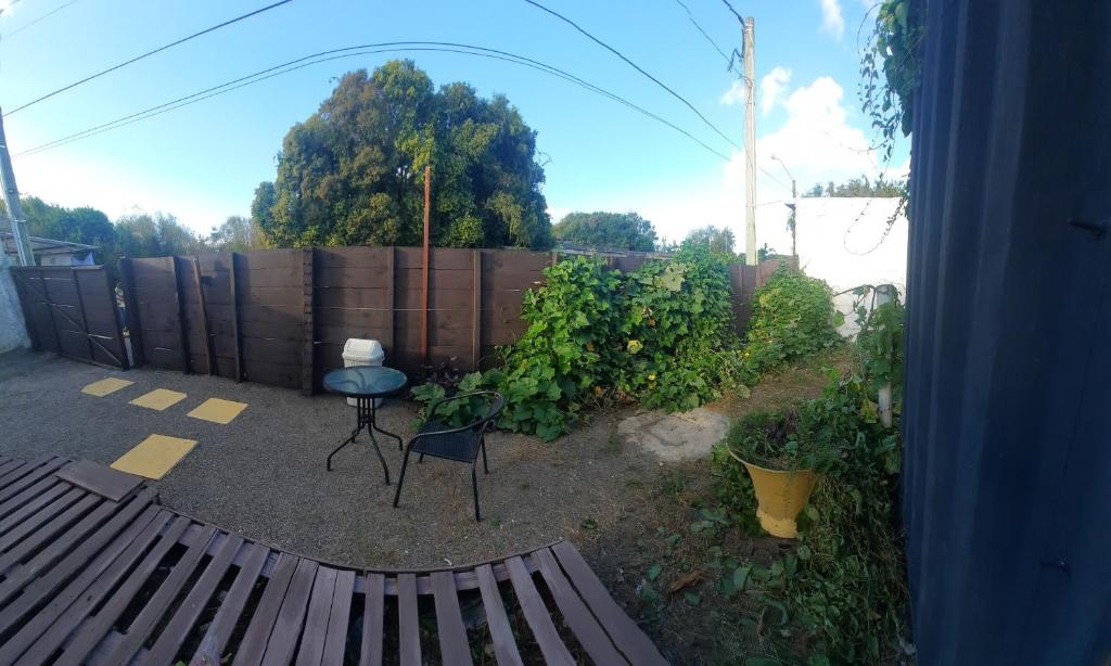 a backyard with a fence and a table and a chair at El rinconcito verde in Minas