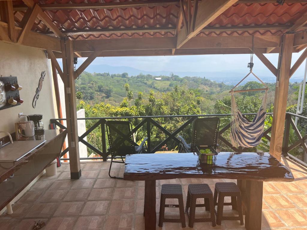 a table and chairs in a kitchen with a view at Burios House in Alajuela