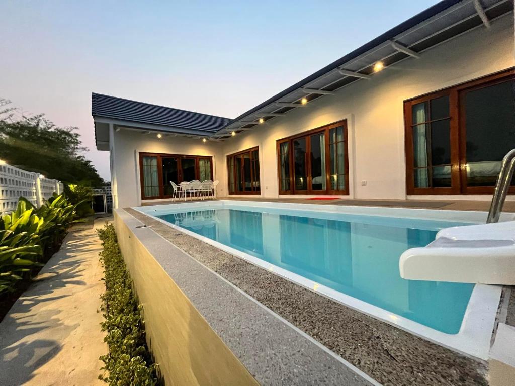 a swimming pool in the backyard of a house at บ้านพูลวิลล่าอุดรธานี by บ้านแสนรัก in Udon Thani
