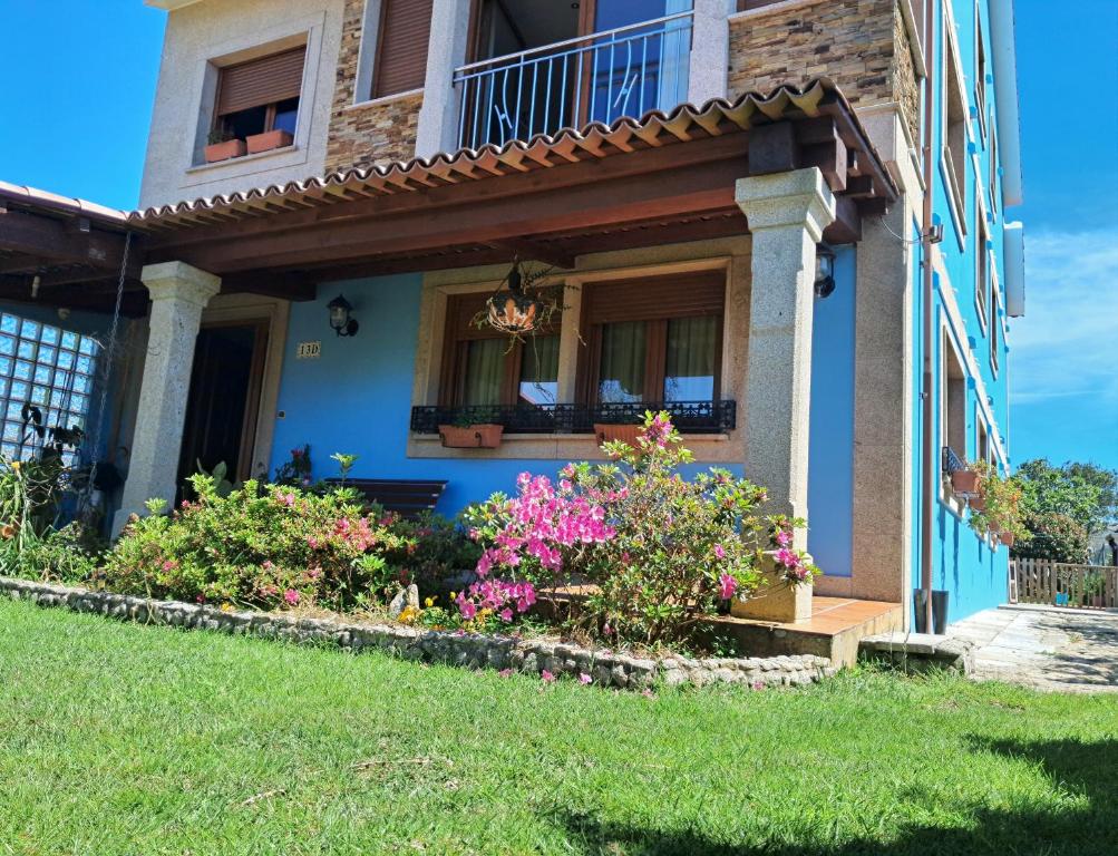 ein Haus mit Blumen auf der Vorderseite in der Unterkunft Apartamento Casa A Braña in O Grove