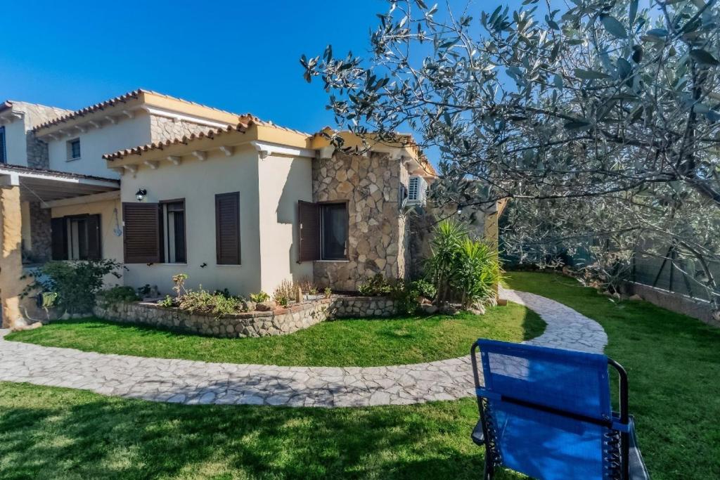 een blauwe bank voor een huis bij Ferienhaus mit Privatpool für 7 Personen ca 100 qm in Castiadas, Sardinien Sarrabus Gerrei in Olìa Speciosa
