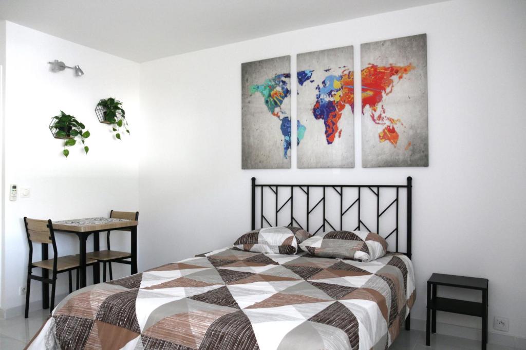 - une chambre avec un lit et 4 cartes murales dans l'établissement Studio cosy front de mer à 5min de Nice, à Saint-Laurent-du-Var