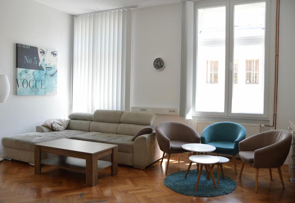a living room with a couch and chairs and a table at Apartment Trdinova in Ljubljana