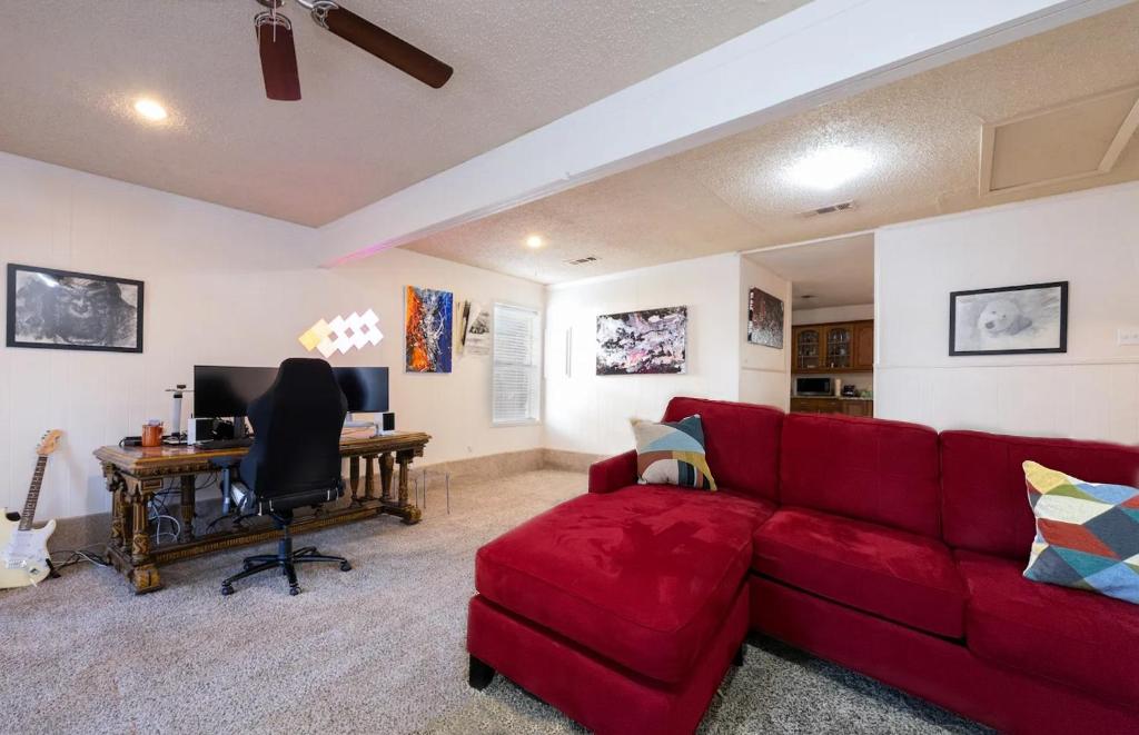 sala de estar con sofá rojo y escritorio en Sunny & Spacious House - Perfectly located for quick access to all of DFW en Farmers Branch