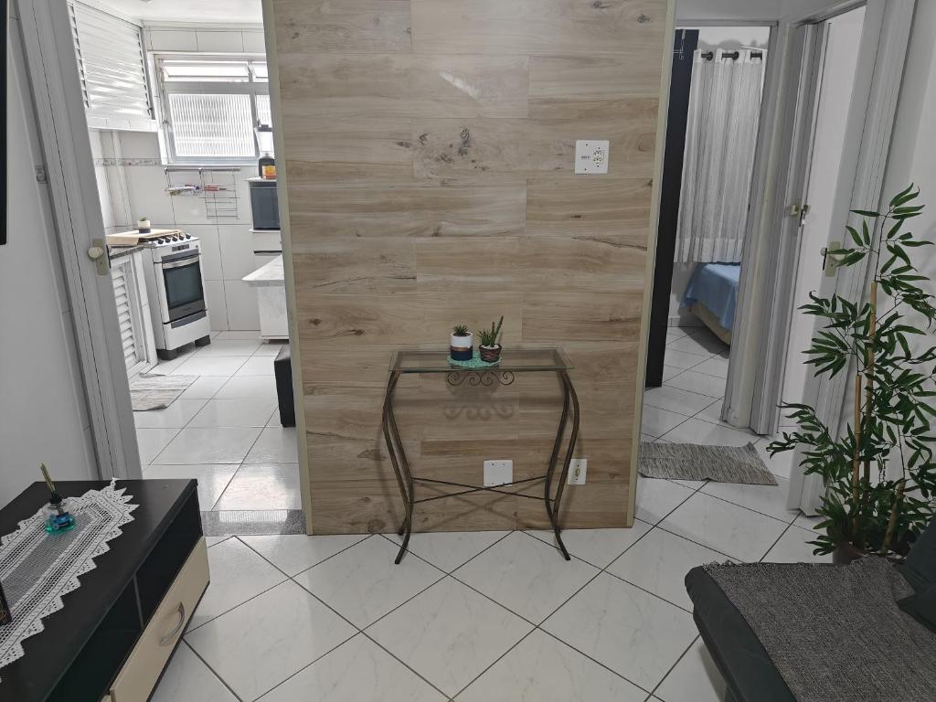 Cette chambre dispose d'une table et d'un mur en bois. dans l'établissement Refúgio Santista - sua casa fora de casa com estacionamento, à Santos