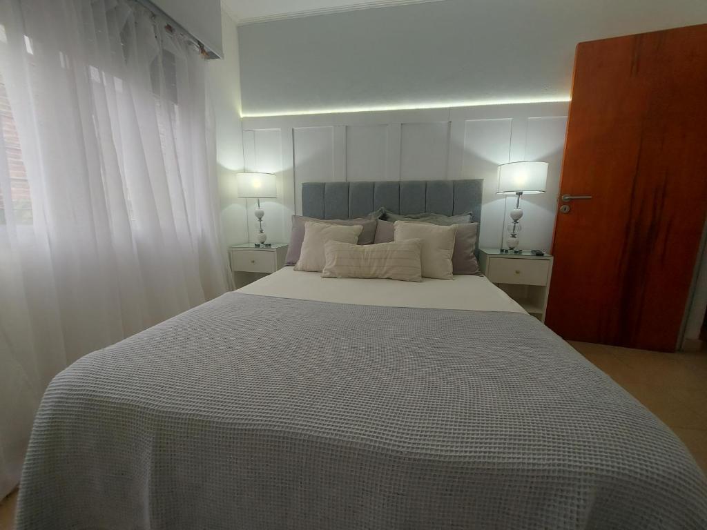 ein Schlafzimmer mit einem großen Bett mit zwei Lampen in der Unterkunft Casa con piscina de uso exclusivo in Gualeguaychú