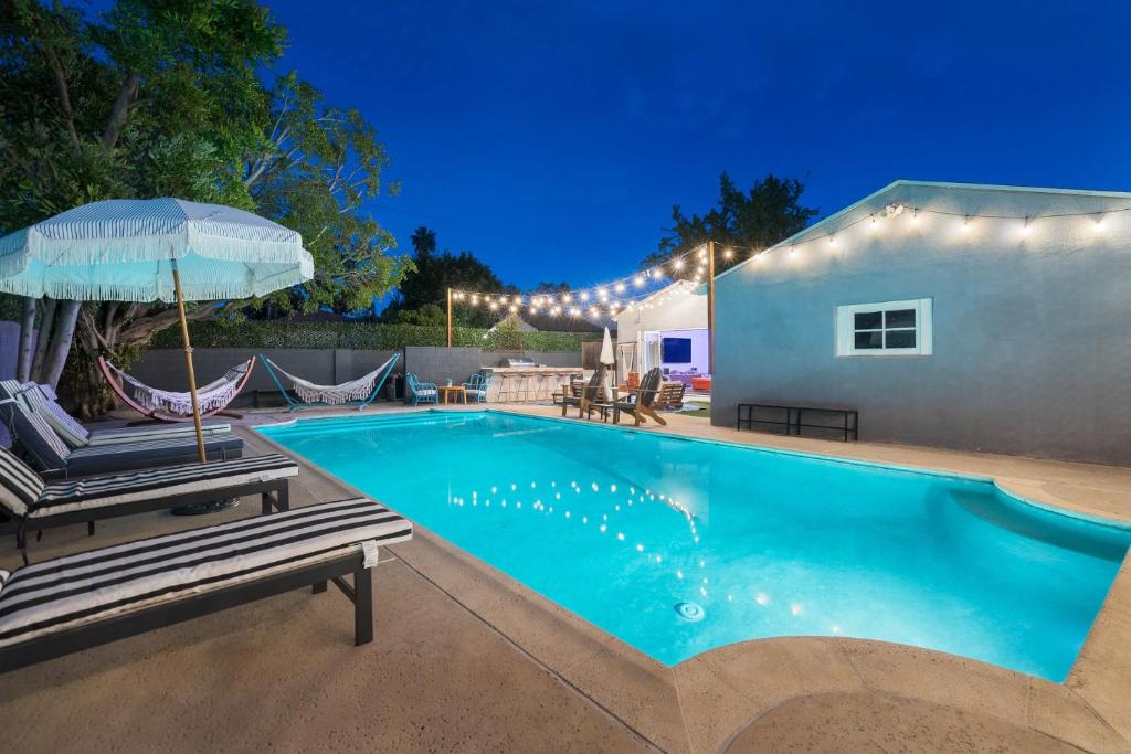 Angel&Rose Universal Hollywood Heated Pool House King Bed في لوس أنجلوس: مسبح مع كرسيين ومظلة