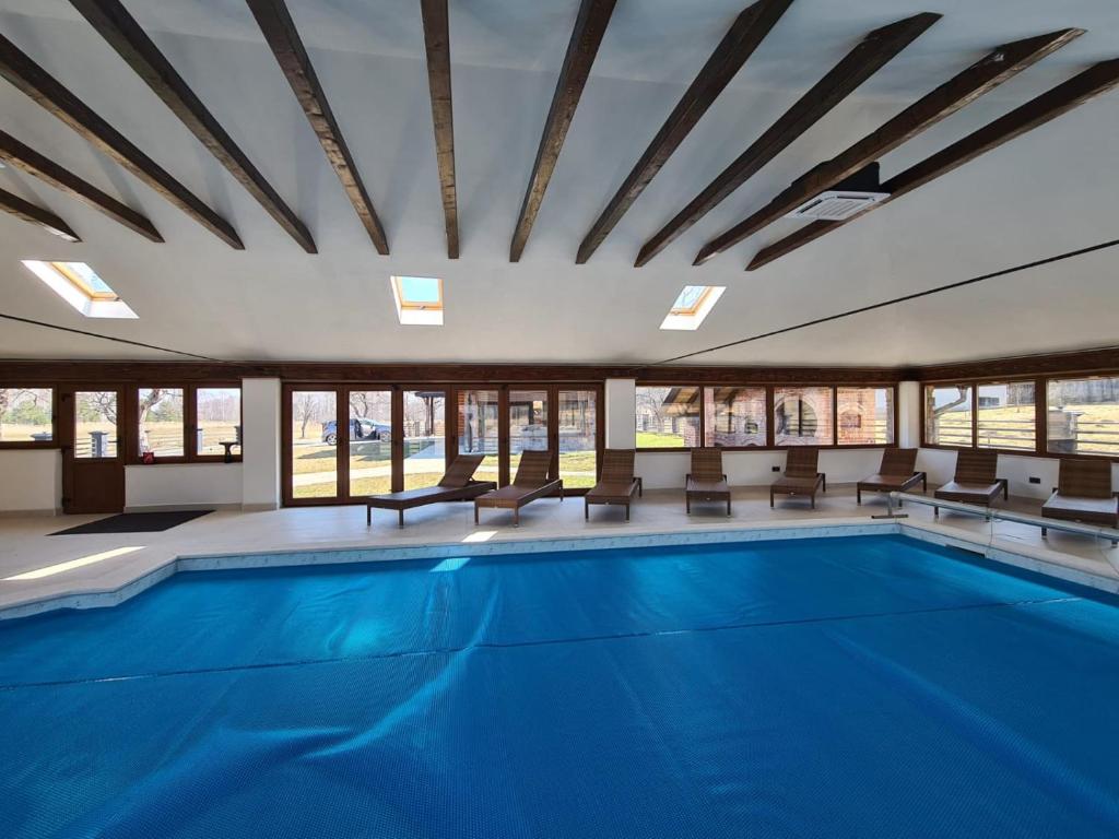 a large swimming pool with chairs and a large room with windows at Rita Luxury Ranch in Gospić