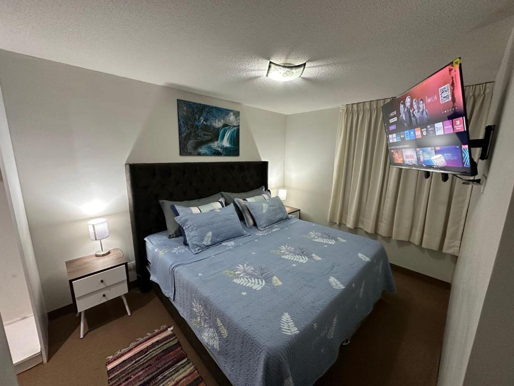 1 dormitorio con 1 cama con edredón azul en 595 Departamento en Chorrillos en Lima