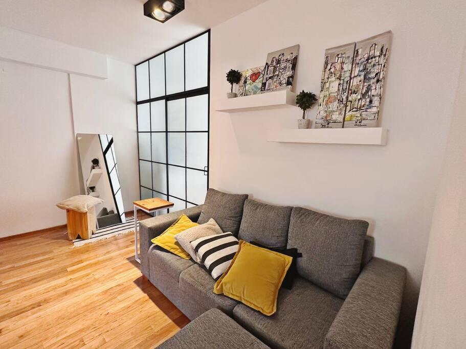 a living room with a gray couch and yellow pillows at Romántico apartamento en el corazón de Palermo. in Buenos Aires