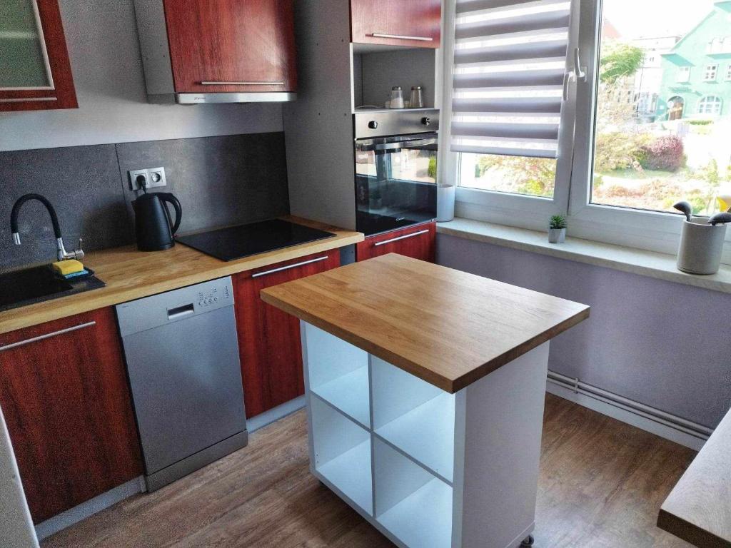 a kitchen with a wooden counter top and a sink at Apartament Kajki in Mrągowo