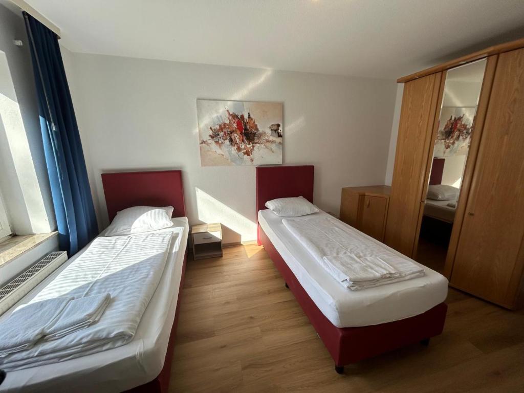 Habitación con 2 camas y espejo. en Othman Appartements Alte Schmiede 2 OG L en Hannover