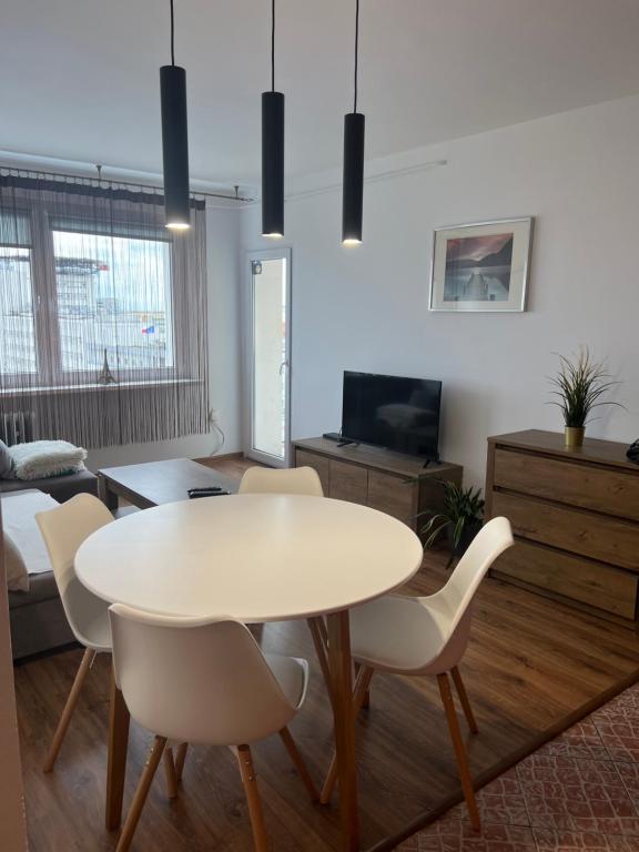 ein Wohnzimmer mit einem weißen Tisch und Stühlen in der Unterkunft mieszkanie in Gdynia