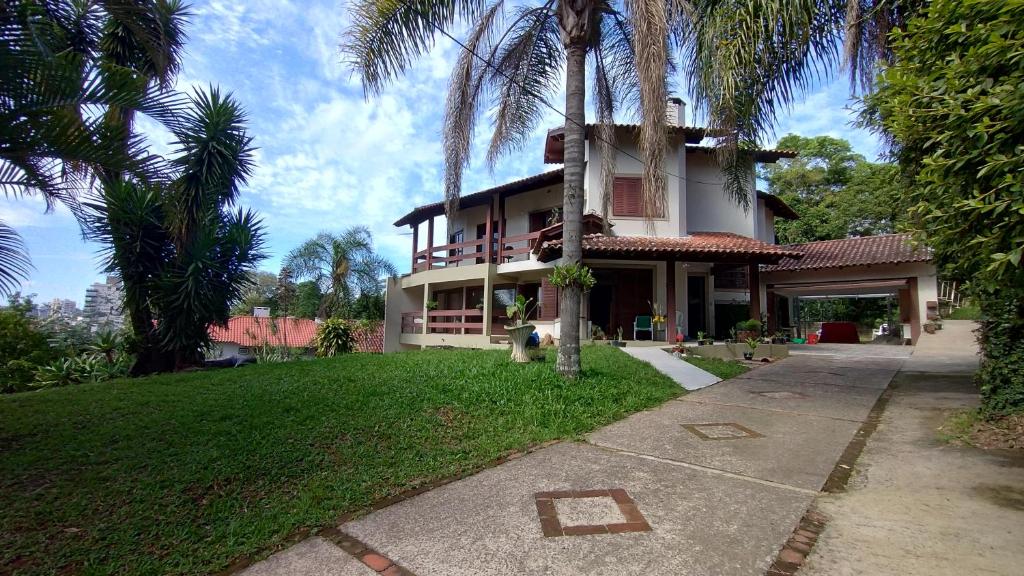 a house with palm trees in front of it at Hostel de Gaia in Santa Cruz do Sul