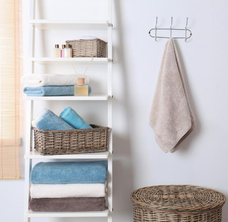 a white towel rack with baskets and towels at Luxury Central Apartment in London
