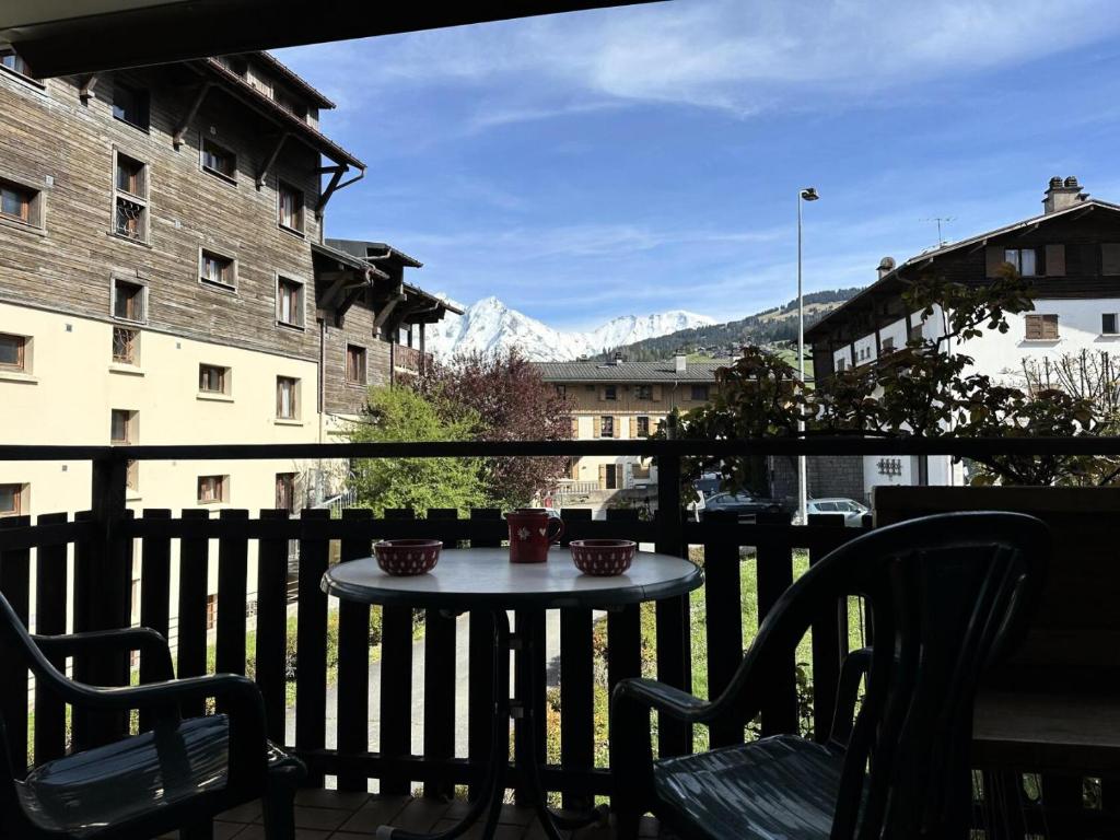 d'une table sur un balcon avec vue sur les montagnes. dans l'établissement Résidence Le Royal - Charmant T3 dans le centre de Combloux MAE-2721, à Combloux