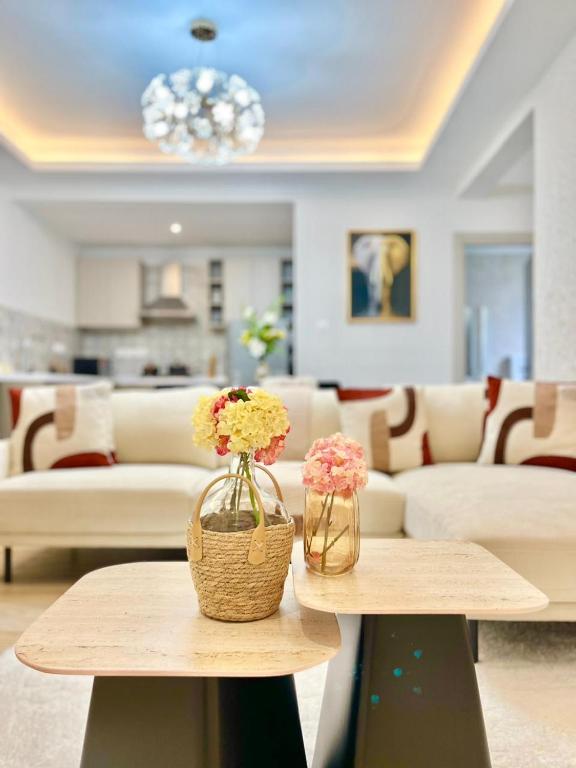 uma sala com duas mesas com flores em Melodious homes elite residency em Nairobi