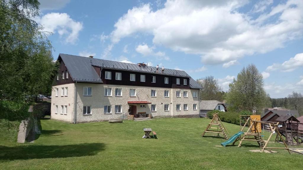 una casa grande con un patio con parque infantil en Hotel Rohanov en Lhota nad Rohanovem