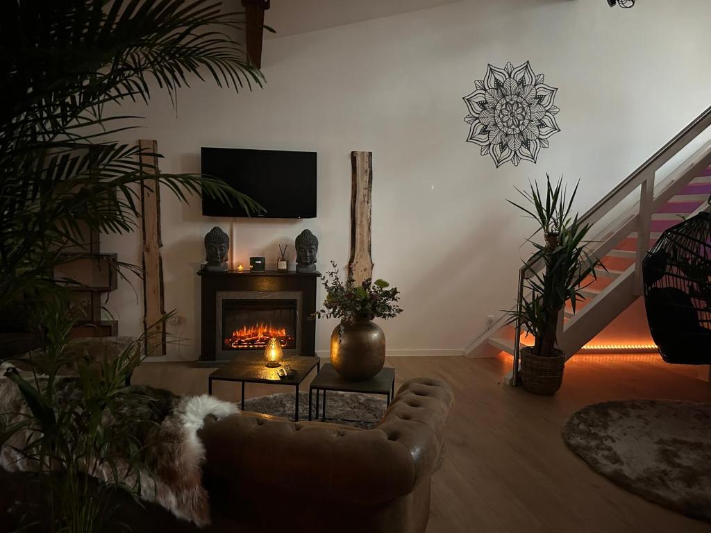 sala de estar con sofá y chimenea en Wellness Suite mit Whirlpool und Sauna, en Ahlen