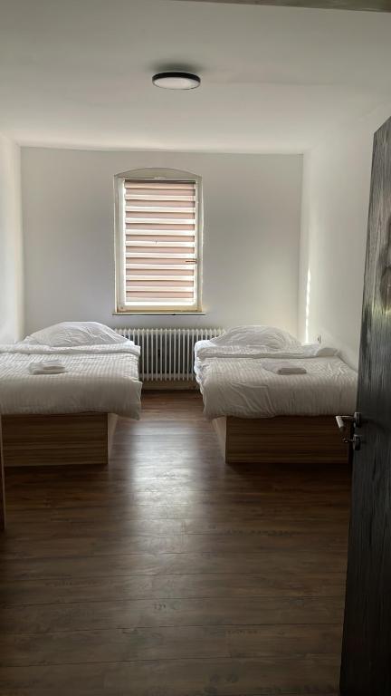 2 Betten in einem Zimmer mit Fenster in der Unterkunft Tacidur Home in Tuttlingen