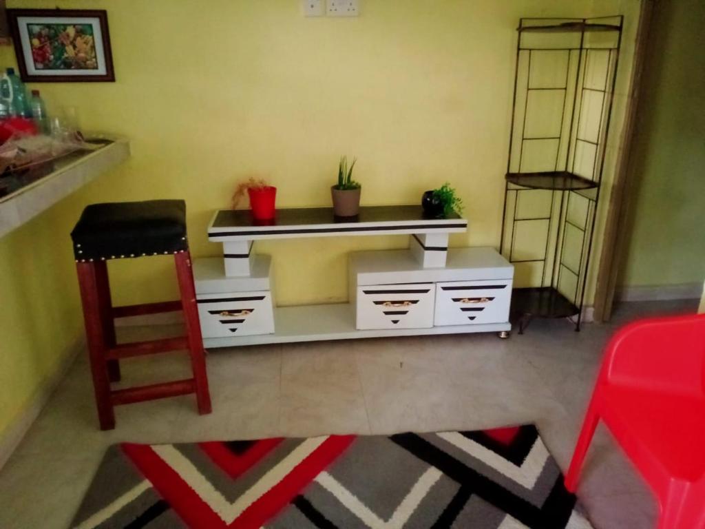 een kamer met een bureau met potplanten en een stoel bij Stay with Daktari Homes in Homa Bay