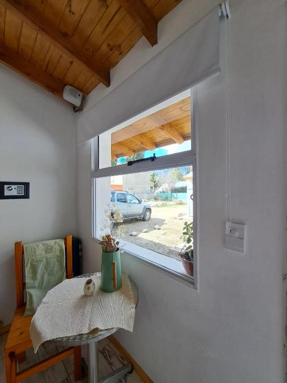 um pequeno quarto com uma mesa e uma janela em Apartamentos-Cabañas Encanto II em El Bolsón