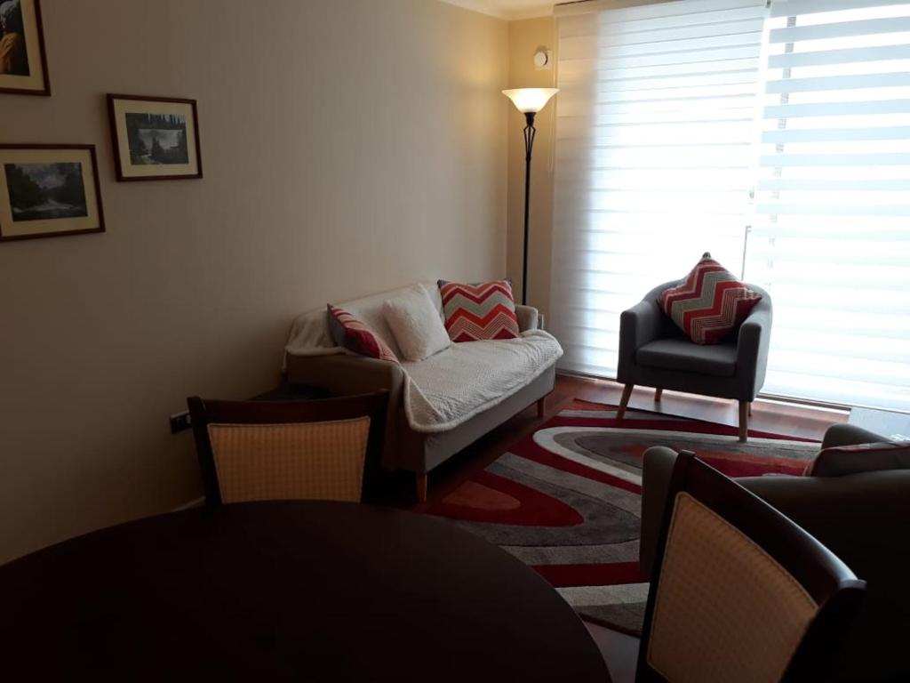 una sala de estar con un sofá y una silla en Los Quillayes, en Los Ángeles