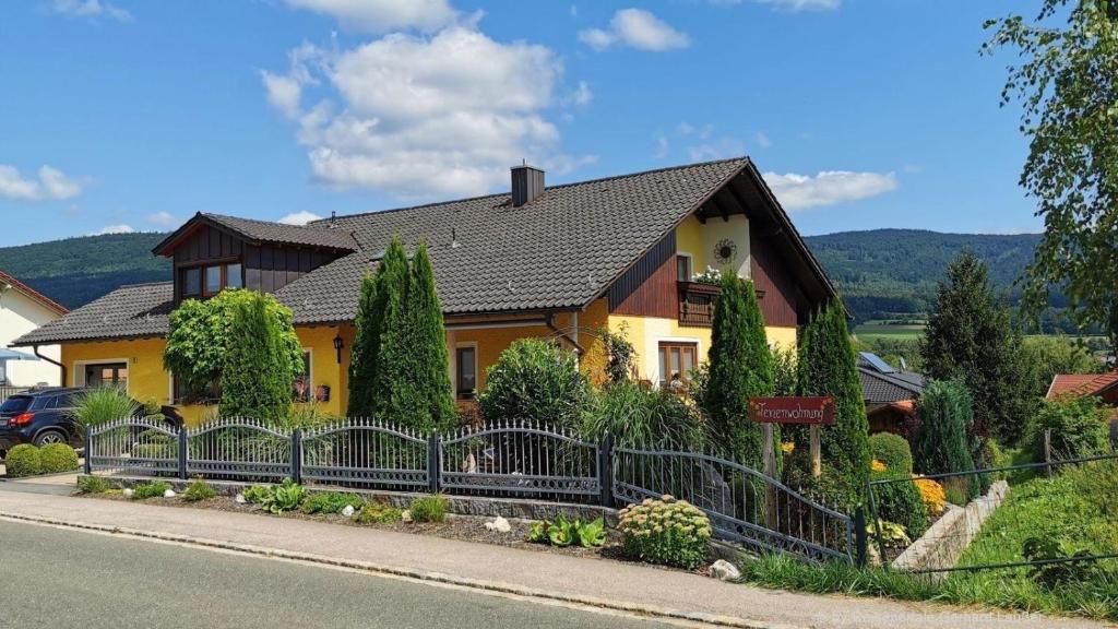 una casa con una valla delante de ella en Ferienwohnung für 2 Personen 1 Kind ca 80 qm in Gleißenberg, Bayern Bayerischer Wald, en Gleißenberg