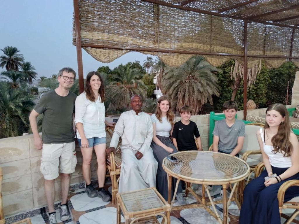 a group of people posing for a picture on a patio at ABU Guest House in Aswan