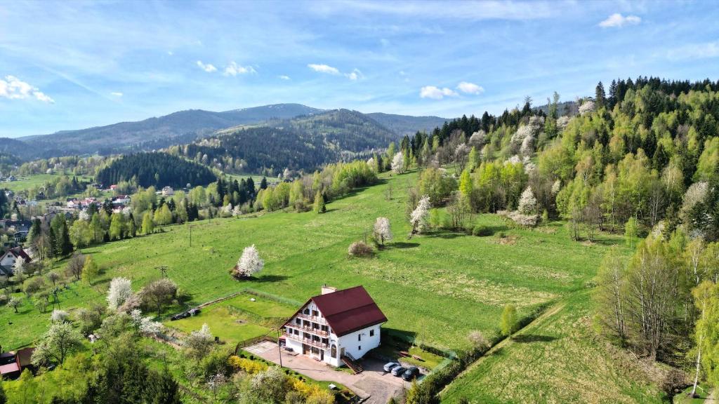 uma casa numa colina num campo verde em Panorama em Korbielów