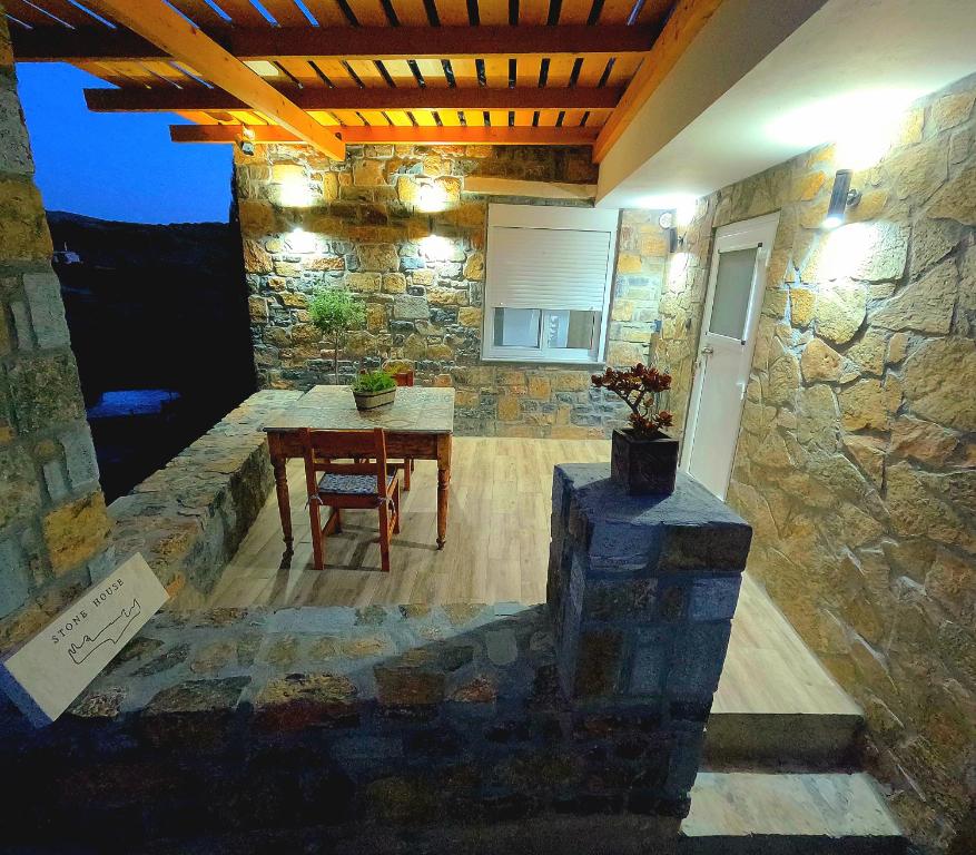 d'une terrasse avec une table et un mur en pierre. dans l'établissement Stone House, à Siteía