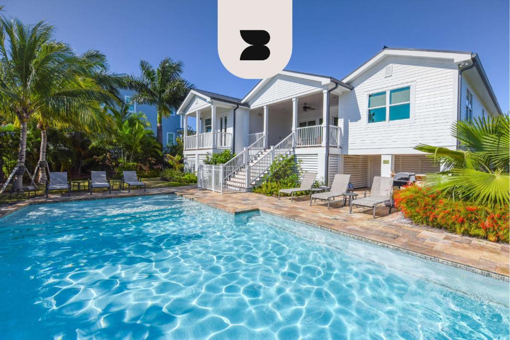 a house with a swimming pool in front of a house at Papa's Abode by Brightwild-Huge Home & Pool in Stock Island