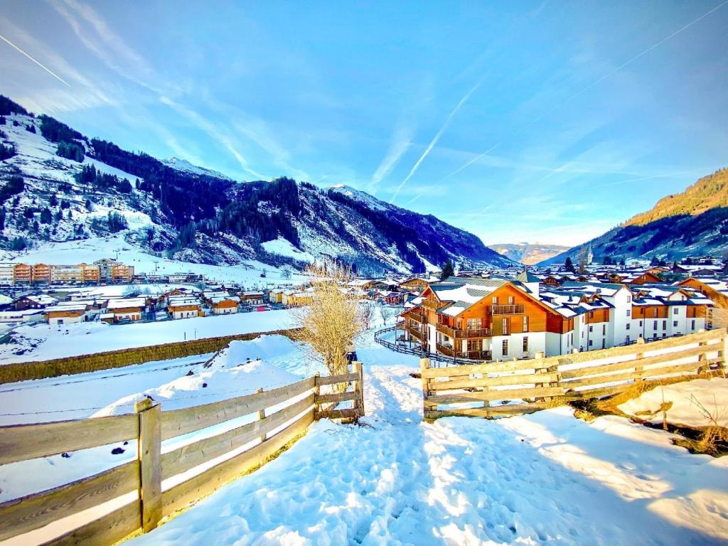 uma aldeia coberta de neve com uma cerca em Ferienwohnung für 4 Personen ca 55 qm in Rauris, Salzburger Land Rauristal em Rauris